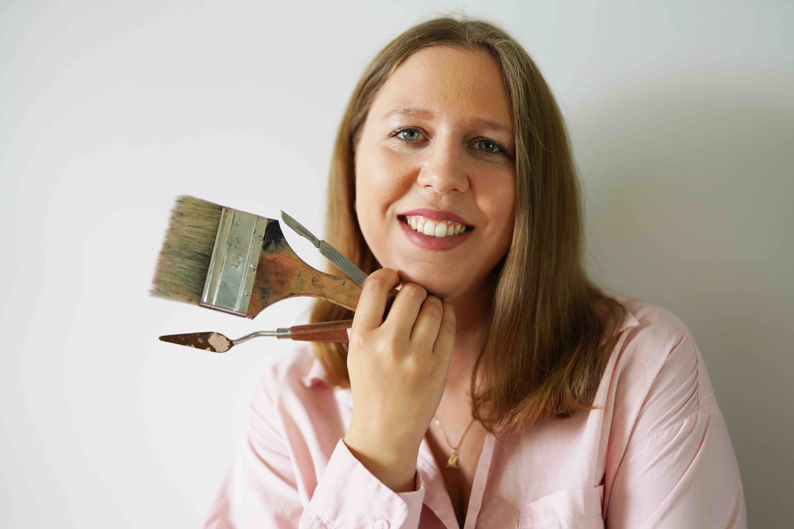 Zdjęcie przedstawia właścicielkę firmy, trzymającą narzędzia.